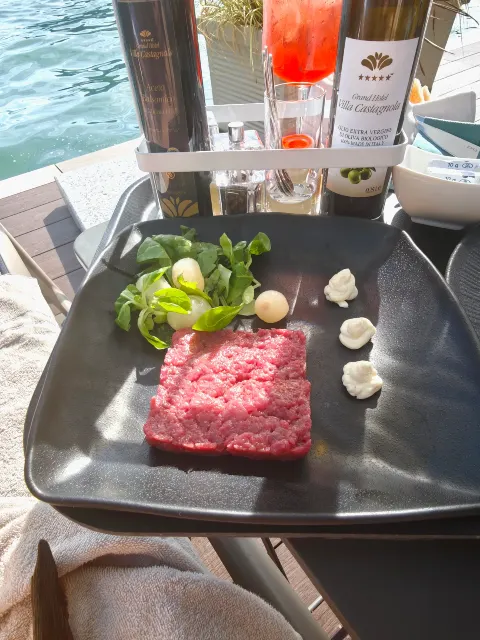 Tartare de bœuf classique aux herbes fraîches, servi au bord de l'eau.