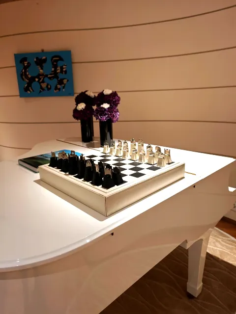 Un jeu d'échecs élégant posé sur le piano à queue blanc.